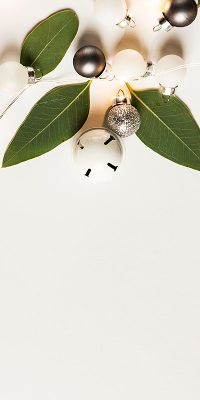 Bells, lights and leaves on white background for holiday feel